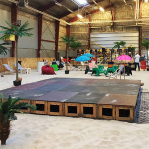 scenepodier i træ opstillet indendørs i hal med sand på gulvet